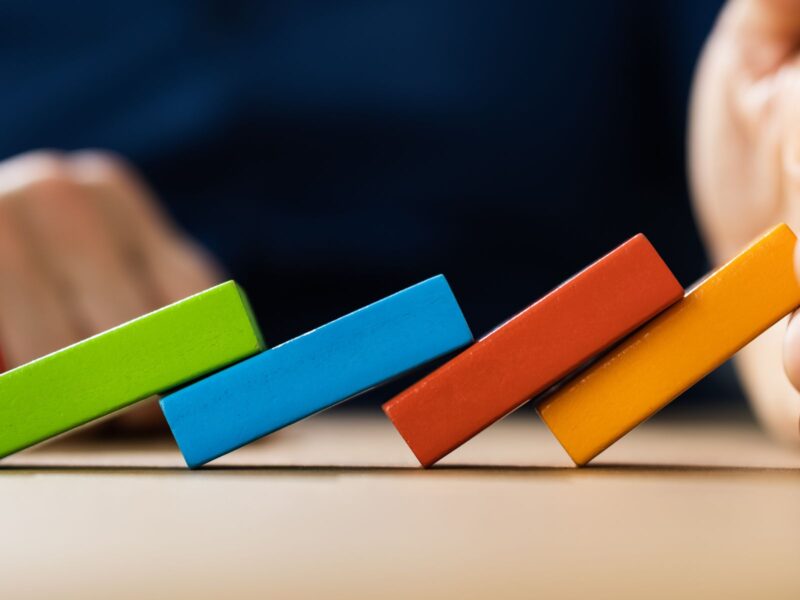 Mano sosteniendo fichas de colores que se caen