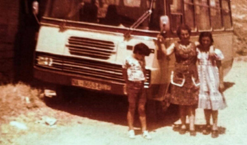 Foto antigua de María José Martínez Navarro, primera mujer en sacarse ek carnet de autobús en Navarra y de las primeras de España, junto a sus hijos delante de un autobús