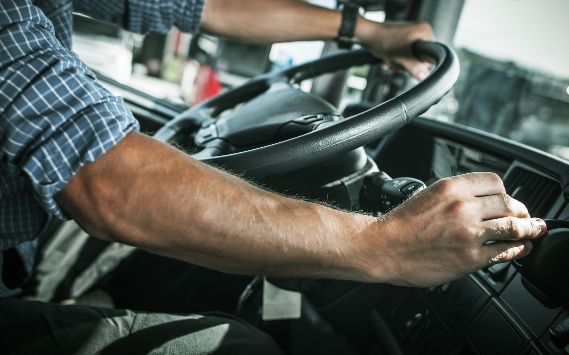 Manos sobre el volante de un vehículo pesado