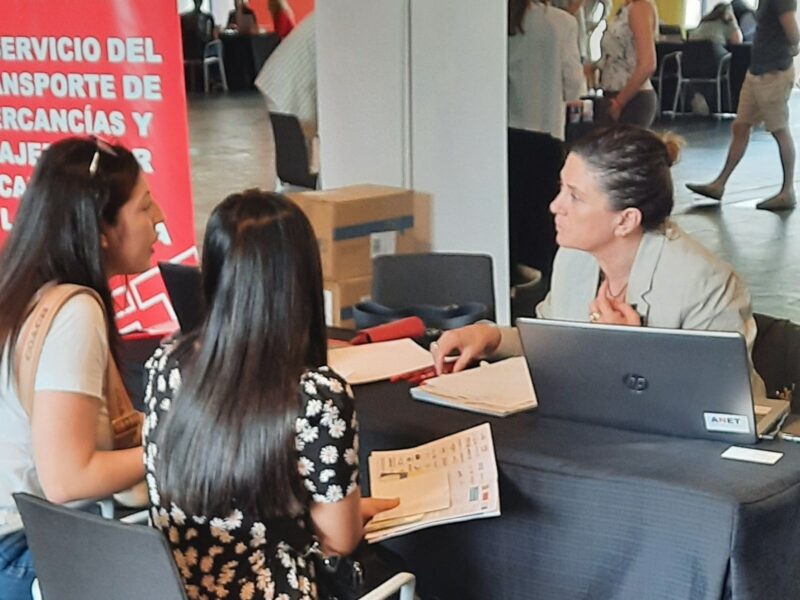 Natalia Aguirre, responsable de Formación de ANET, atendiendo a dos jóvenes en el NavarraJobs 2023