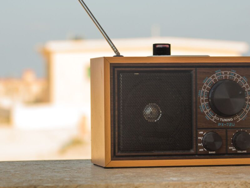 Imagen de una radio sobre un balcón con un paisaje de ciudad lluvioso de fondo